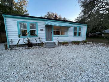 Charming bungalow with a white exterior, teal accents, and a striped awning at 1374 20Th St, Sarasota, FL 34234