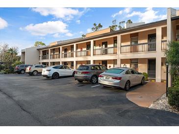 Exterior view of condo building with ample parking at 2522 Clubhouse Dr # 204, Sarasota, FL 34232