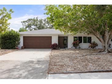 Charming single-story home with a brown garage door, white siding, and landscaped front yard at 346 Suwanee Ave, Sarasota, FL 34243