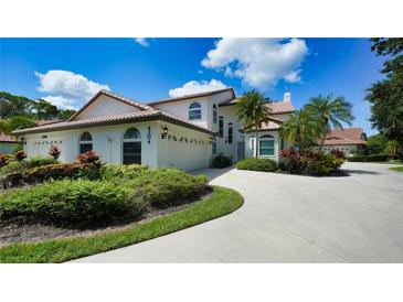 Charming two-story home with a tile roof, attached garage, and lush landscaping at 4304 Camino Madera, Sarasota, FL 34238