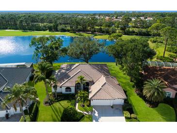 Single-Gathering home with lake views, two-car garage, and lush landscaping at 8790 Merion Ave, Sarasota, FL 34238