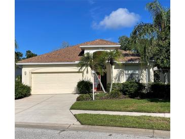 Charming single-story home featuring a well-manicured lawn and a two-car garage at 8412 Whispering Woods Ct, Lakewood Ranch, FL 34202