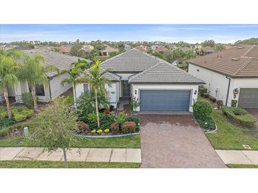 Single-story home with gray roof, gray garage door, and landscaped front yard at 1724 Hyssop Loop, North Port, FL 34289