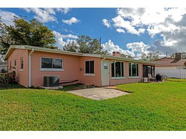 Pink house with a spacious backyard, patio, and grassy lawn at 2506 41St E St, Bradenton, FL 34208