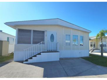 Tan mobile home with white trim, steps, and railing. Situated in a mobile home community at 3333 26Th E Ave # 1148, Bradenton, FL 34208
