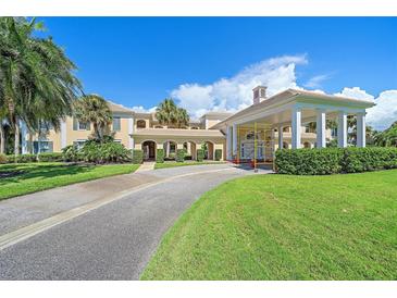 Resort-style building with palm trees and a landscaped entrance at 51 Macewen Dr # 20, Osprey, FL 34229