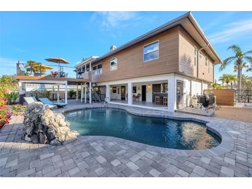 Stunning outdoor pool with a rock feature and spacious patio, perfect for relaxation and entertaining at 521 Cummings St, Sarasota, FL 34242