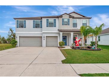 Two-story home with a two-car garage and landscaped lawn at 7404 Mill Hopper Ct, Palmetto, FL 34221