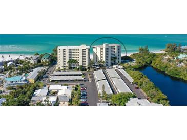 Beautiful aerial view of two condominium buildings and a white sand beach on the Gulf of Mexico at 19 Whispering Sands Dr # 301, Sarasota, FL 34242