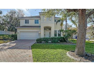 Two-story house with a white exterior, brick driveway, and lush green lawn at 6963 74Th Street E Cir, Bradenton, FL 34203