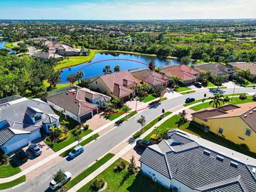 Aerial view of a luxurious home community with a lake at 19864 Petrino St, Venice, FL 34293