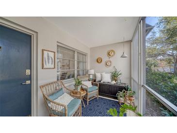 Relaxing screened patio with wicker chairs and lush greenery at 3745 Almeria Ave # 3S, Sarasota, FL 34239