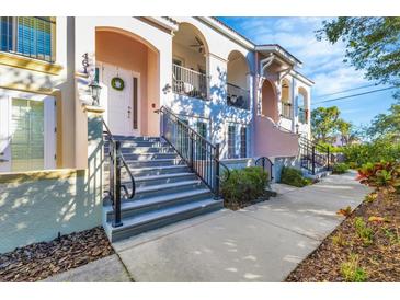 Charming townhome exterior featuring arched entryways, wrought iron railings, and a welcoming front door with wreath at 461 Nokomis S Ave, Venice, FL 34285