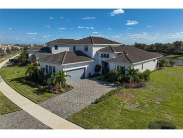 Luxury home with paver driveway and lake view in a community at 5035 Kiva Cir, Bradenton, FL 34211