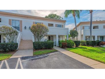 Exterior view of condo building with landscaping and walkway at 5242 Wedgewood Ln # 62, Sarasota, FL 34235