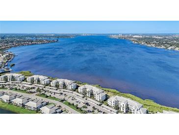 Aerial view of waterfront condo building with parking and lush landscaping at 1010 Tidewater Shores Loop # 103, Bradenton, FL 34208