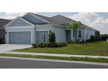 Two-story house with gray siding, two-car garage, and landscaped yard at 4406 Rustling Pines Ter, Parrish, FL 34219