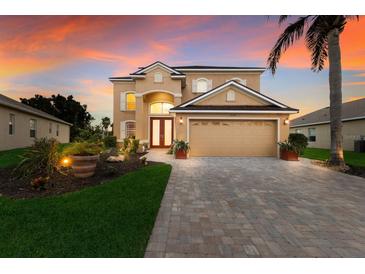 Two-story house with a tan exterior, two-car garage, and landscaped yard at 3618 Summerwind Cir, Bradenton, FL 34209