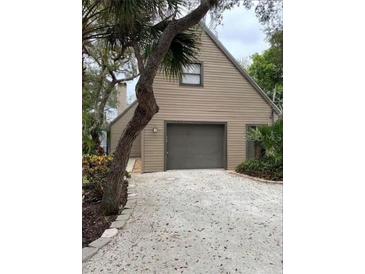 Tan house with gray garage door and gravel driveway at 5311 Creek Dr, Sarasota, FL 34231