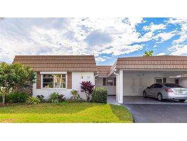 Front view of charming single story home with carport and landscaped lawn at 5474 Riverbluff Cir # V35, Sarasota, FL 34231