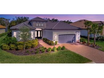 Exterior of a single-story home with a gray garage door and landscaped yard at 15415 Derna Ter, Bradenton, FL 34211