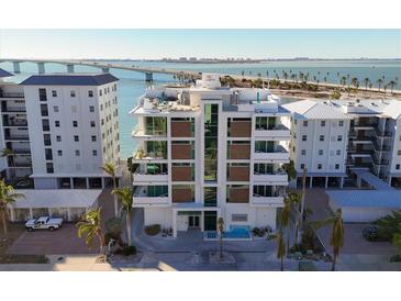 Aerial view of modern waterfront building, showcasing luxurious design and stunning bay views at 188 Golden Gate Pt # 202, Sarasota, FL 34236