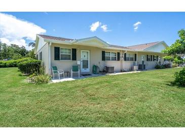 Tan house with green accents and a small front patio at 2771 Golf Course Dr # 101, Sarasota, FL 34234
