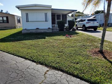 Single-wide mobile home with carport and well-maintained lawn at 5504 Bermuda Ct, Bradenton, FL 34207