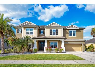 Inviting two-story home featuring a well-maintained lawn, lush landscaping, and a two-car garage at 6318 Anise Dr, Sarasota, FL 34238