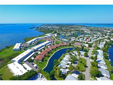 Scenic aerial view of waterfront condos, serene lake, and lush landscaping in a vibrant community at 9411 Andover Cir, Bradenton, FL 34210