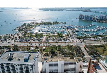 Aerial view of waterfront property with marina, city skyline, and nearby buildings at 33 S Gulfstream Ave # 402, Sarasota, FL 34236