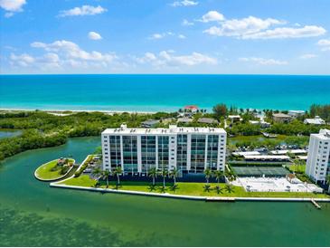 Aerial view of waterfront condo building with pool and tennis court at 9397 Midnight Pass Rd # 906, Sarasota, FL 34242