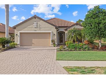 Single-story home with a two-car garage, landscaping, and a brick driveway at 12606 Fontana Loop, Bradenton, FL 34211