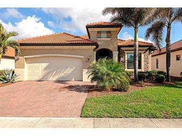 Single-story home with a tile roof, two-car garage, and landscaped yard at 24160 Gallberry Dr, Venice, FL 34293