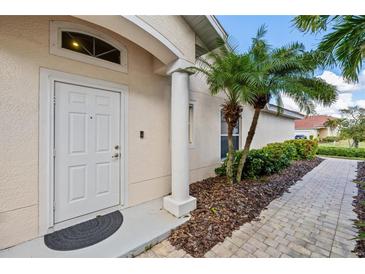Inviting entryway with white door, columned porch, and landscaped walkway at 3841 Albacete Cir # 51, Punta Gorda, FL 33950