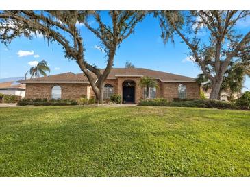 Brick house with a large front yard and mature trees at 2957 Wilderness E Blvd, Parrish, FL 34219