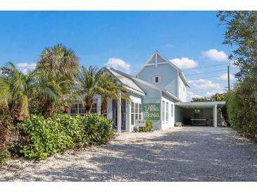 Charming light blue two-story home with a landscaped front yard and driveway at 307 Spring Ave, Anna Maria, FL 34216