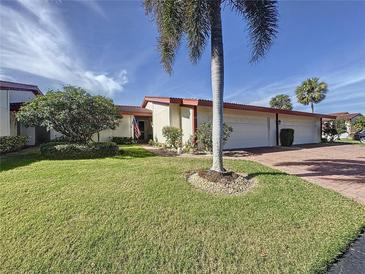 Exterior view of charming villa with 2-car garage, lush landscaping, and beautiful palm tree at 707 Sorrento Inlt # 707, Nokomis, FL 34275