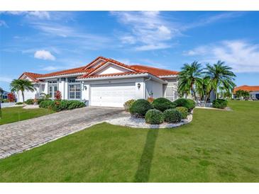 Single-story home with tile roof, landscaped yard, and two-car garage at 741 Fairway Ridge Ct, Sun City Center, FL 33573