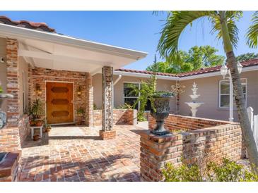 Inviting front entrance with brick accents, wooden door, fountain, and lush landscaping at 2605 Desoto Rd, Sarasota, FL 34234