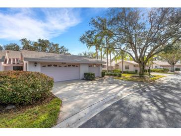 Two-car garage and driveway with manicured landscaping at 5436 Hampstead Heath # 25, Sarasota, FL 34235