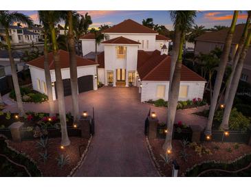 Stunning two-story home with red roof, circular driveway, and lush tropical landscaping at 367 W Royal Flamingo Dr, Sarasota, FL 34236