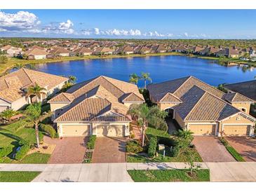 An aerial view showcases beautiful homes and a tranquil lake reflecting the surrounding community at 21620 Avon Park Ct, Venice, FL 34293