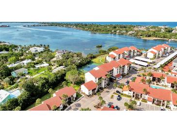 Stunning aerial view of a waterfront condo community with lush landscaping and serene water views at 1626 Stickney Point Rd # 26-102, Sarasota, FL 34231