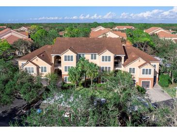 Beautiful exterior of this multistory condo with a brown roof, beige exterior walls, palm trees and mature trees surrounding it at 4152 Central Sarasota Pkwy # 727, Sarasota, FL 34238