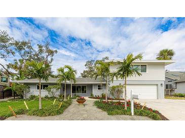 Charming two-story home featuring a well-manicured lawn with beautiful palm trees at 3348 S Seclusion Dr, Sarasota, FL 34239