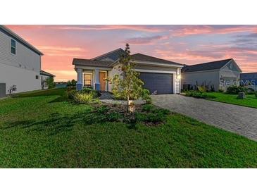 Charming single-story home featuring a well-manicured lawn and a paved driveway leading to an attached garage at 4514 Big Woods Way, Parrish, FL 34219