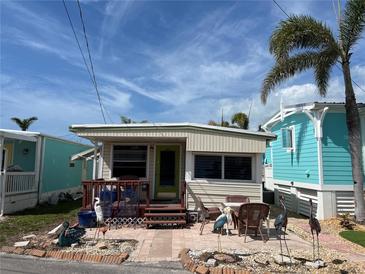 Charming exterior featuring a quaint patio, lovely decor, and a beautiful tropical palm tree at 2601 Gulf N Dr # B16, Bradenton Beach, FL 34217