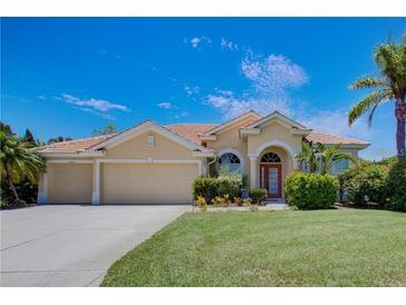 Charming single-story home with a tile roof, lush landscaping, and an attached three-car garage at 644 Rivendell Blvd, Osprey, FL 34229
