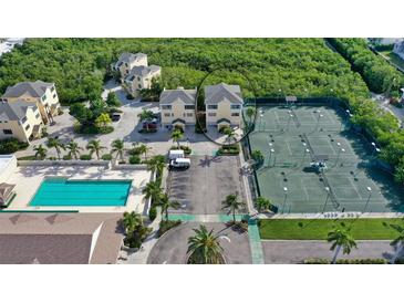 Aerial view of beach condos near a pool, tennis courts and lots of parking at 653 Cedars Ct, Longboat Key, FL 34228